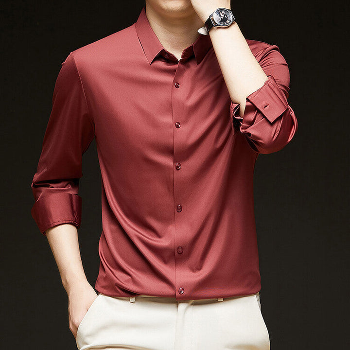 Camicia uomo elegante in seta rossa, maniche lunghe, abbinata a pantaloni chiari. Moda maschile, abbigliamento formale, stile sofisticato.