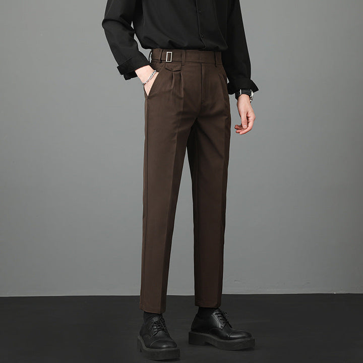 Pantaloni eleganti marroni da uomo con cintura, abbinati a camicia nera e scarpe nere. Moda maschile, abbigliamento formale, stile moderno.