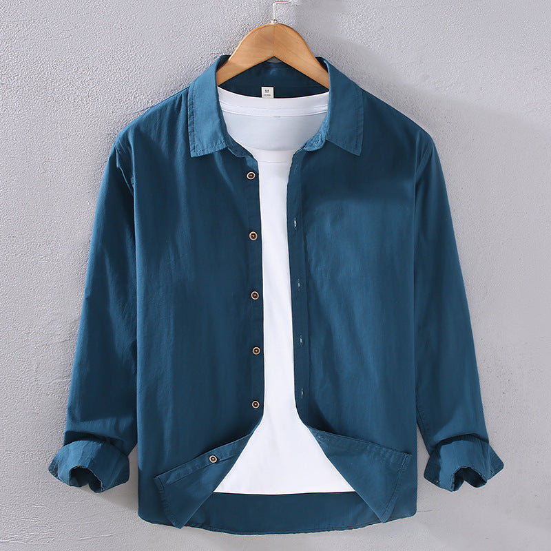 Camicia casual blu da uomo su gruccia, con colletto classico e maniche lunghe, abbinata a t-shirt bianca. Moda maschile, abbigliamento elegante.