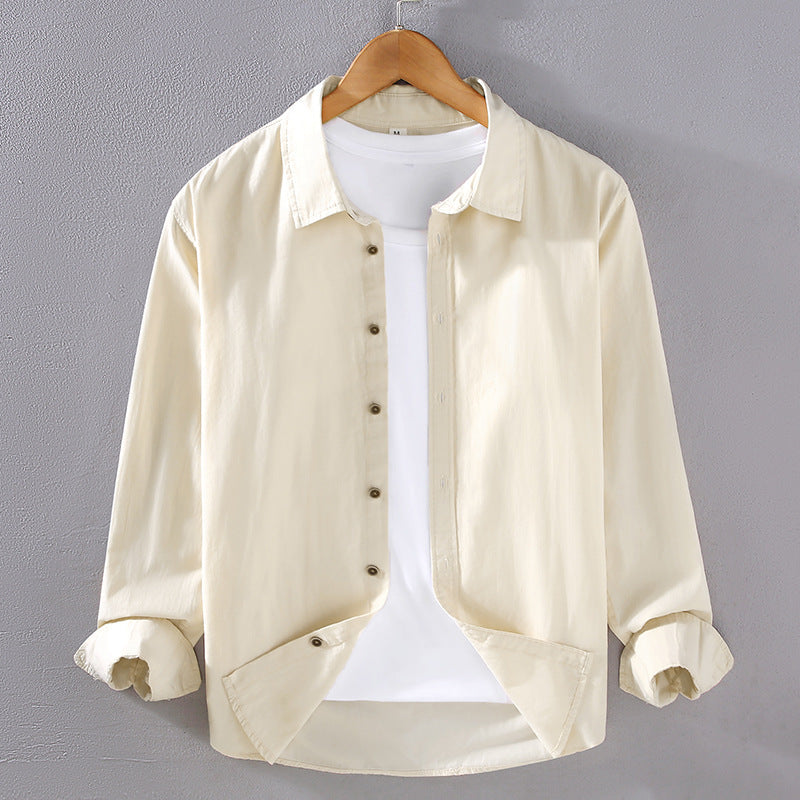 Camicia beige da uomo su gruccia, maniche lunghe, abbinata a t-shirt bianca. Moda casual, abbigliamento maschile, stile elegante.