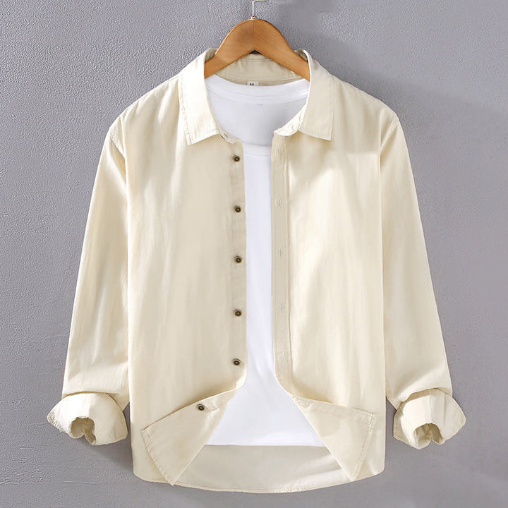 Camicia beige da uomo su gruccia, maniche lunghe, abbinata a t-shirt bianca. Moda casual, abbigliamento maschile, stile elegante.