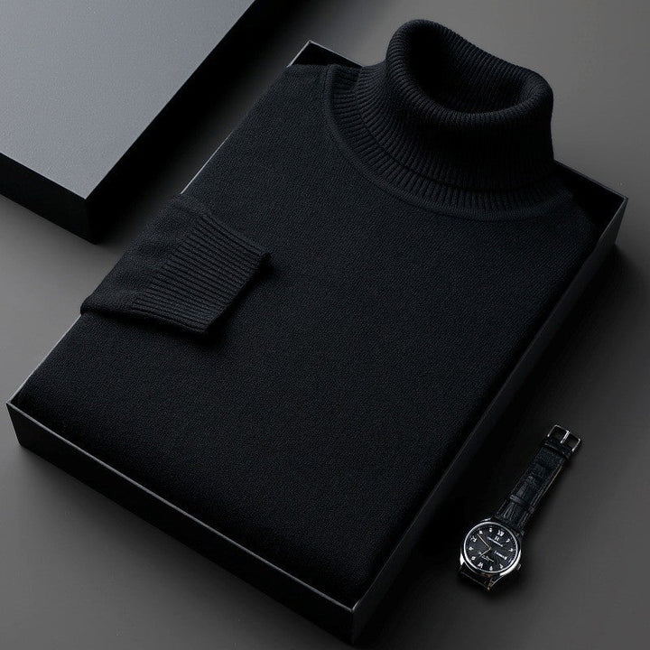 Maglione dolcevita nero elegante in scatola regalo su sfondo grigio, accanto a orologio da polso classico. Moda uomo, abbigliamento invernale.