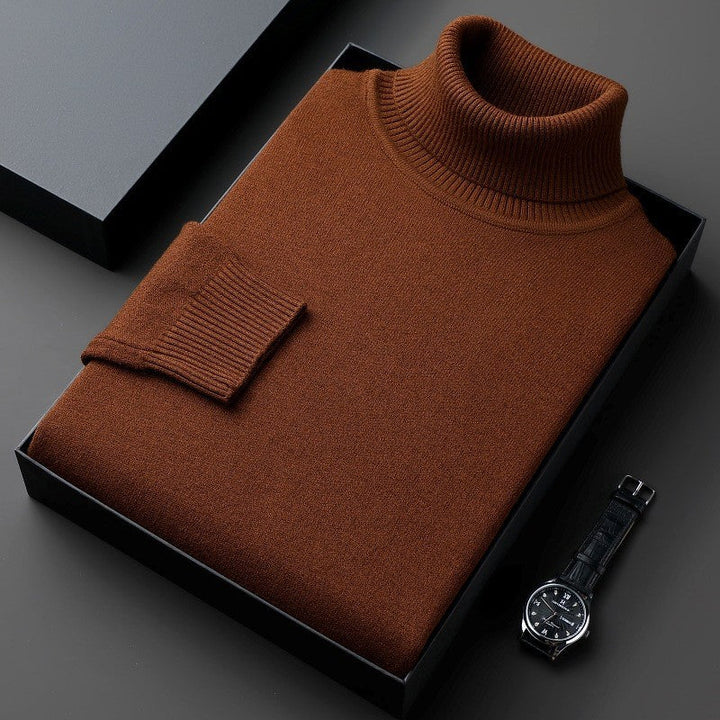 Maglione dolcevita marrone in lana, piegato in scatola nera, accanto a orologio da polso elegante. Moda uomo, abbigliamento invernale di lusso.