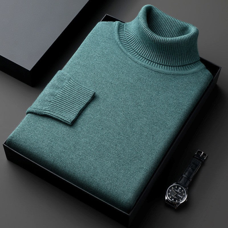 Maglione dolcevita verde piegato in scatola nera, accanto a orologio da polso elegante. Moda uomo, abbigliamento invernale, stile sofisticato.