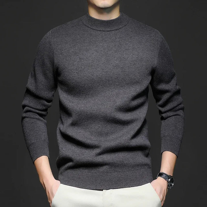 Maglione uomo grigio scuro in lana, maniche lunghe, indossato con pantaloni chiari. Stile casual elegante, moda autunno inverno.