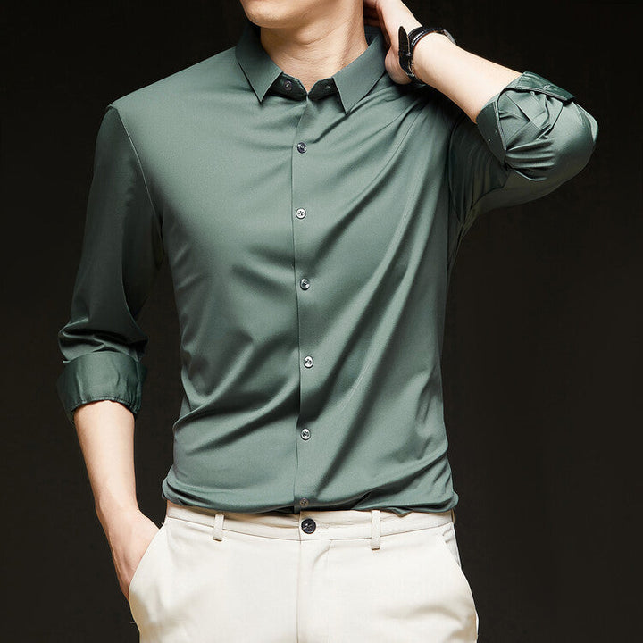 Camicia verde elegante da uomo con maniche arrotolate, abbinata a pantaloni chiari. Moda maschile, abbigliamento casual chic, stile moderno.