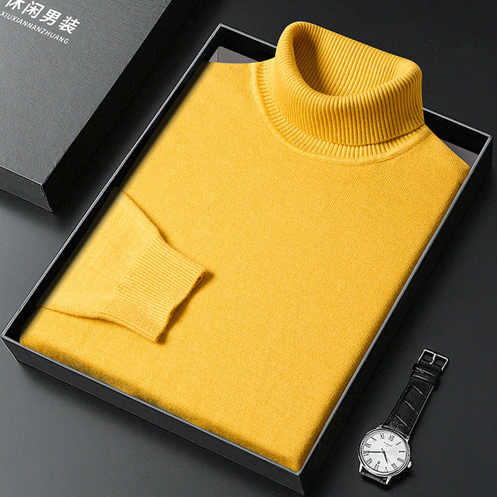 Maglione dolcevita giallo in lana, confezionato in elegante scatola nera, accanto a orologio da polso. Moda uomo, abbigliamento invernale.