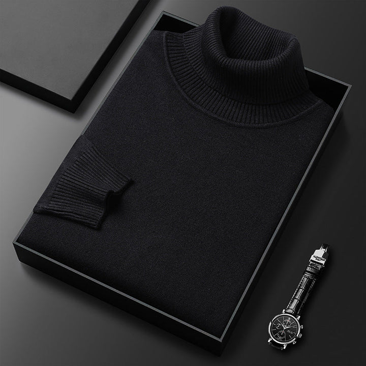 Maglione dolcevita nero elegante in scatola regalo su sfondo nero, accanto a orologio da polso di lusso. Moda uomo, abbigliamento invernale.