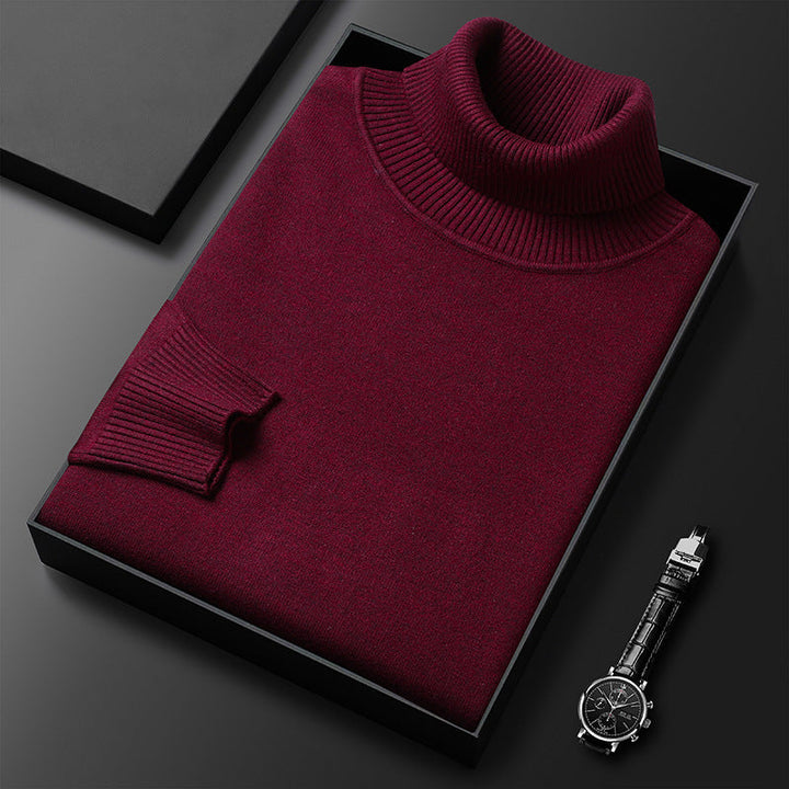 Maglione dolcevita bordeaux in lana, piegato in scatola nera su sfondo scuro, accanto a orologio da polso elegante. Moda uomo, abbigliamento invernale.